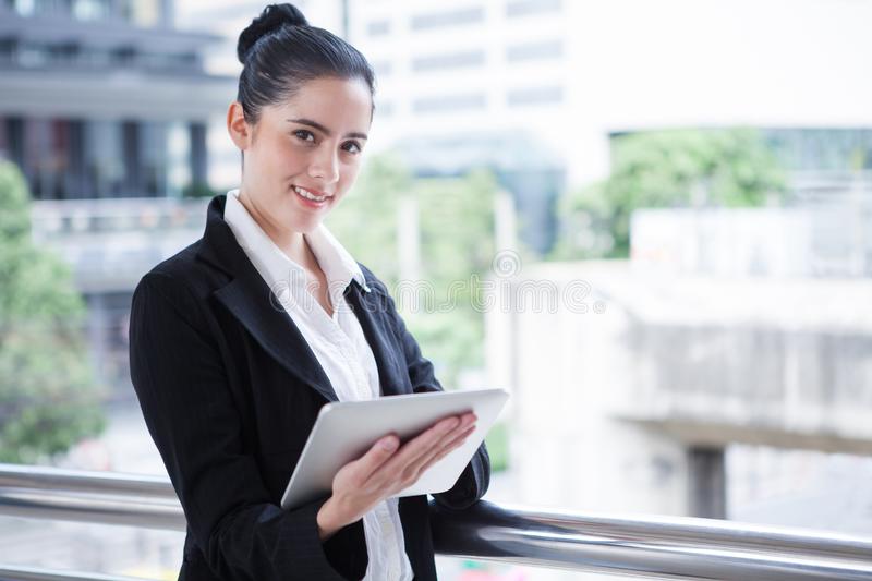 business-woman-using-digital-tablet-computer-outside-office-happy-young-beautiful-girl-working-social-media-outdoor-over-138297111